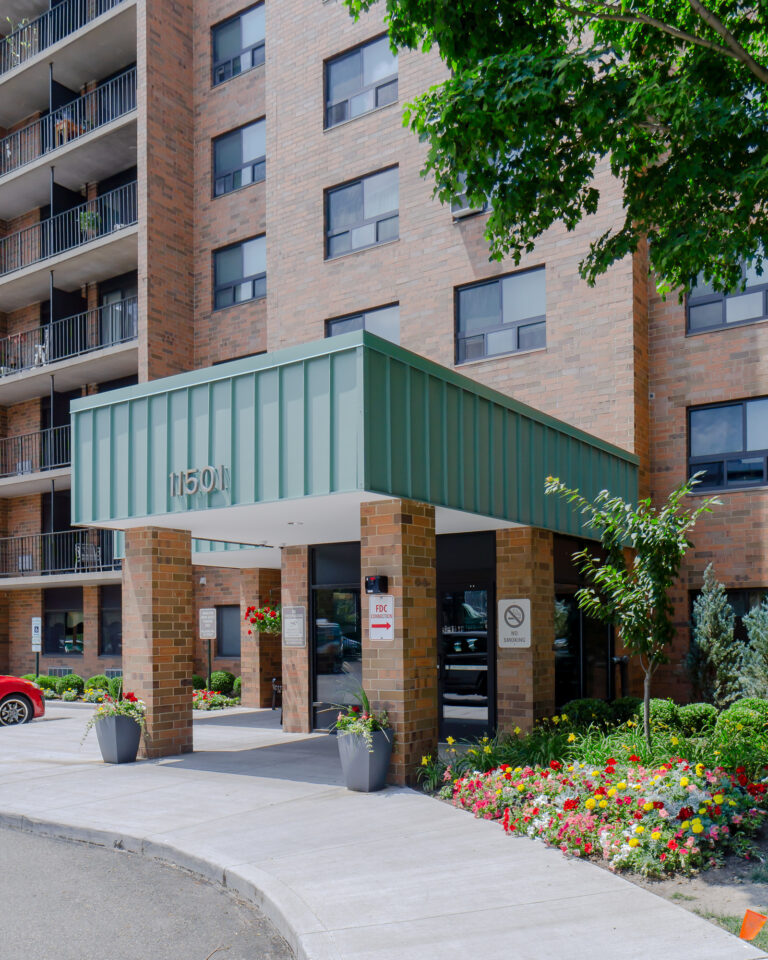 Refreshed main entry canopy with masonry piers and landscaped beds