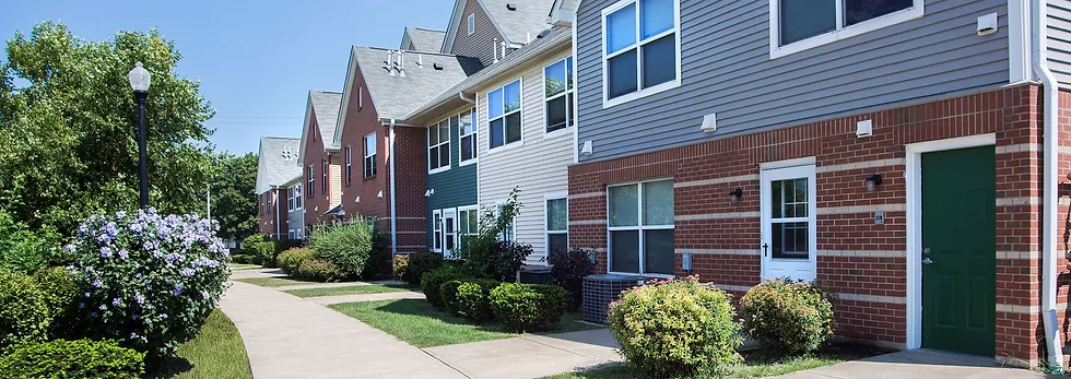 Townhome row with mixed brick and clapboard facades along a landscaped sidewalk
