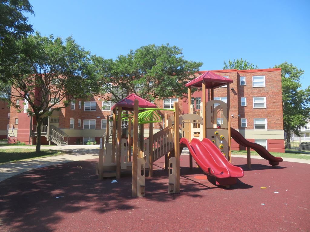 On-site resident playground framed by the rehabilitated Carver Park buildings