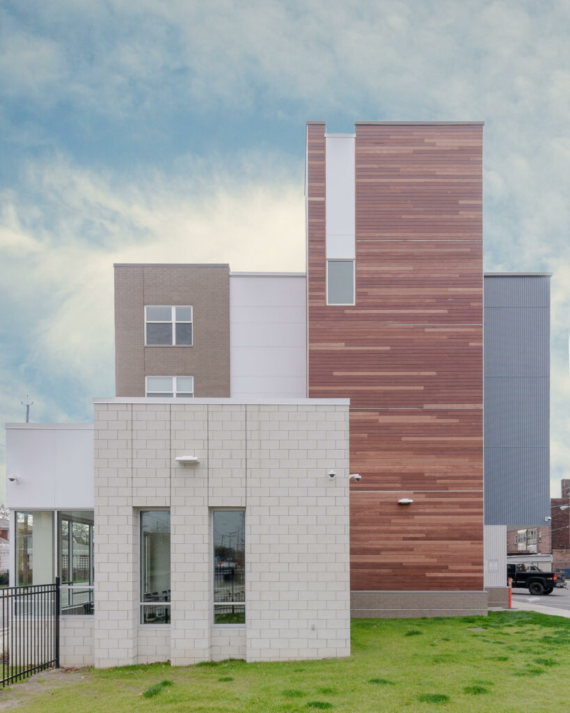 Cedar-clad tower volume rising above the masonry base