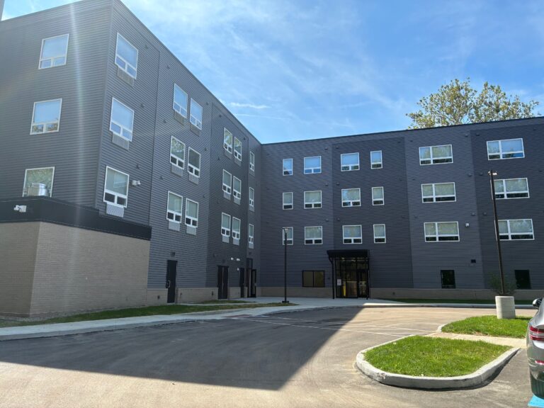 Side elevation showing the residential entry and dark fiber-cement cladding
